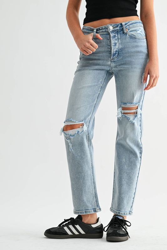 Person wearing ripped blue jeans on a white background