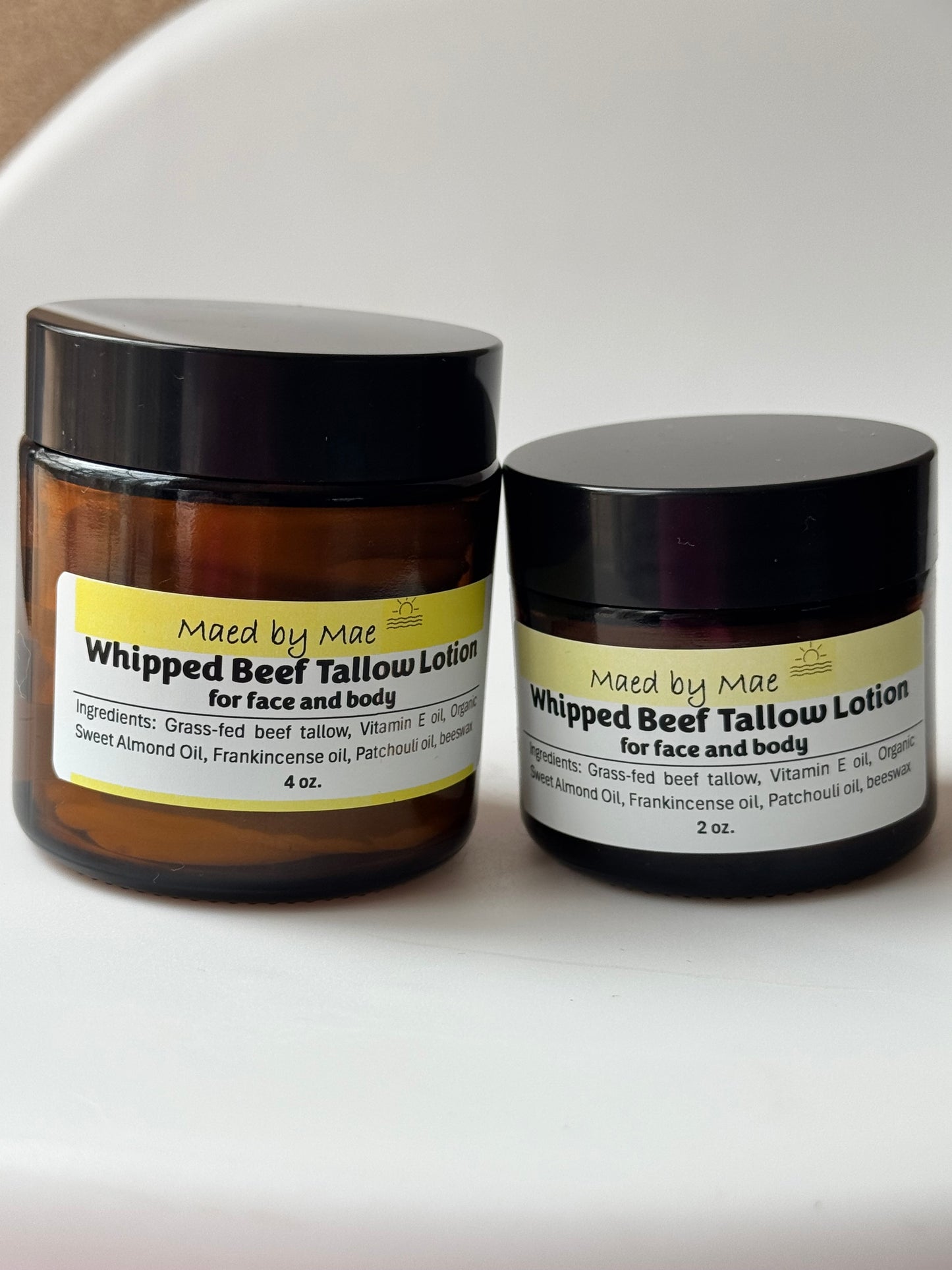 Two jars of Made by Mae whipped beef tallow lotion on a white surface.