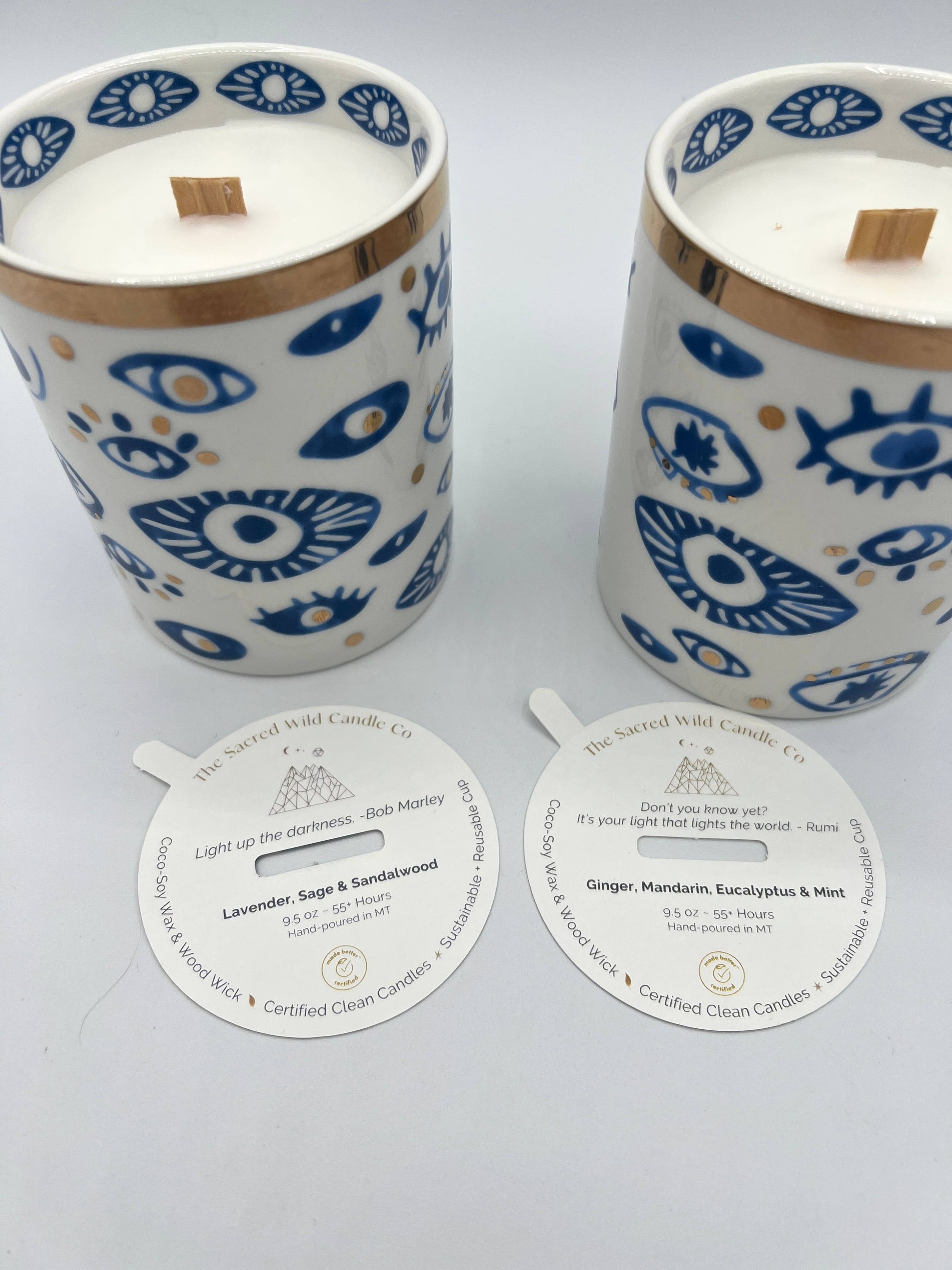 Two candles with decorative lids and labels on a light gray background