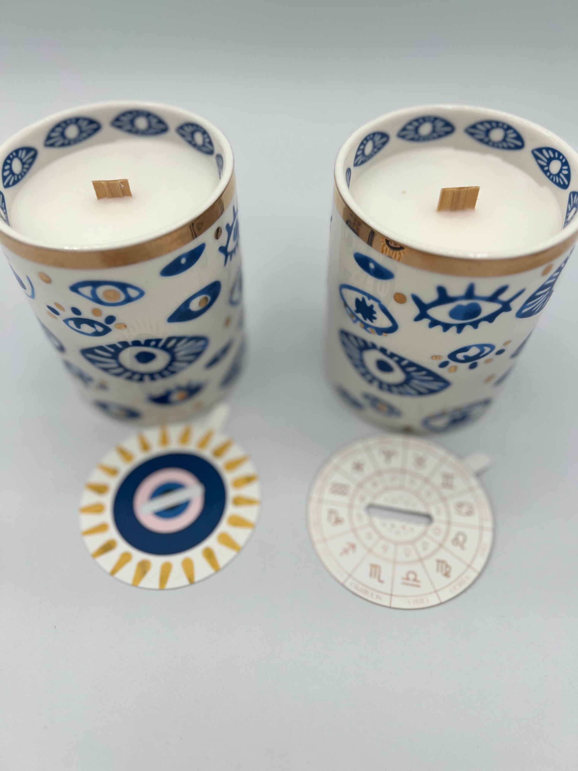 Two candles with decorative lids on a light gray background