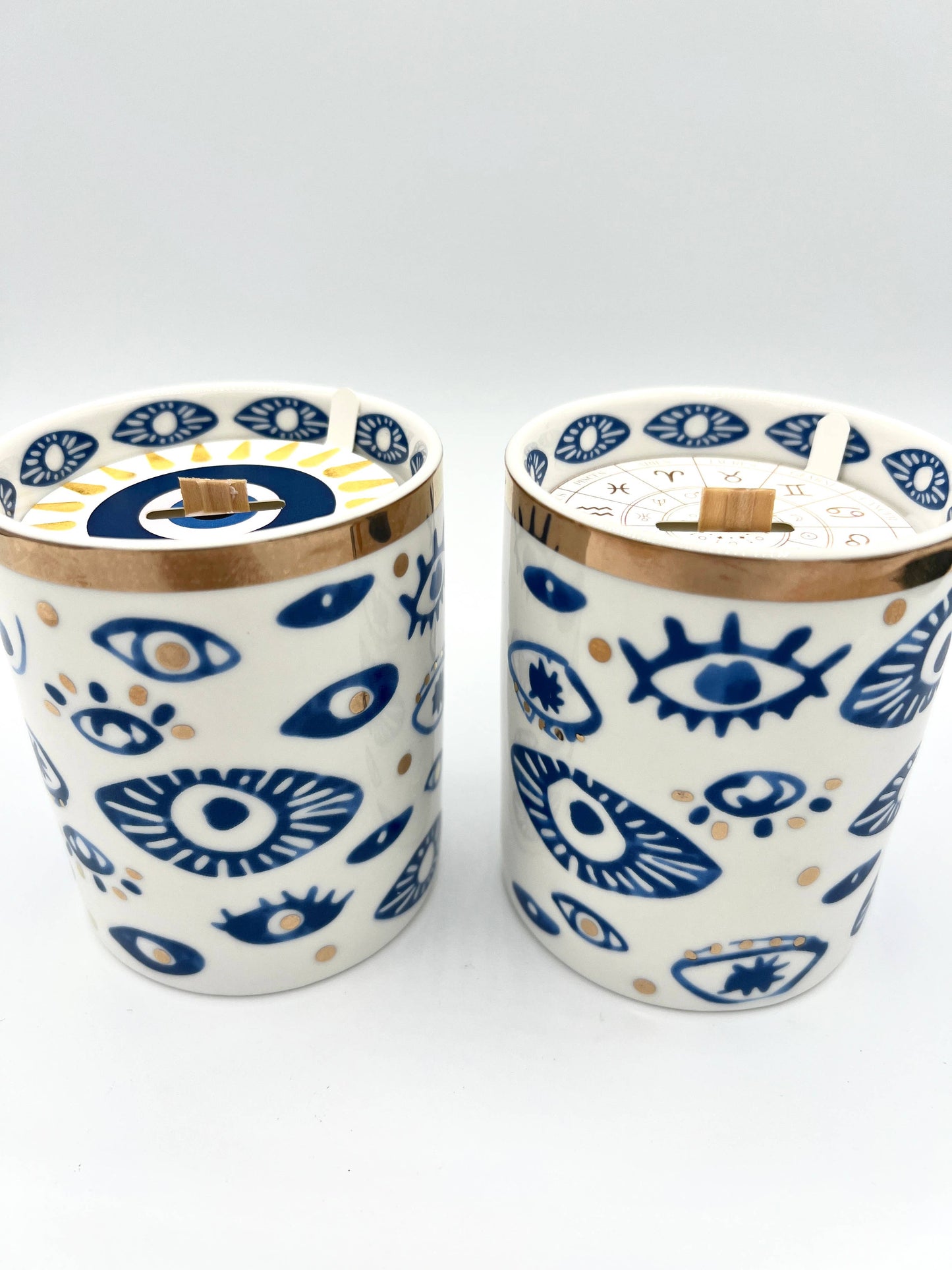 Two ceramic tumblers with eye pattern on a white background