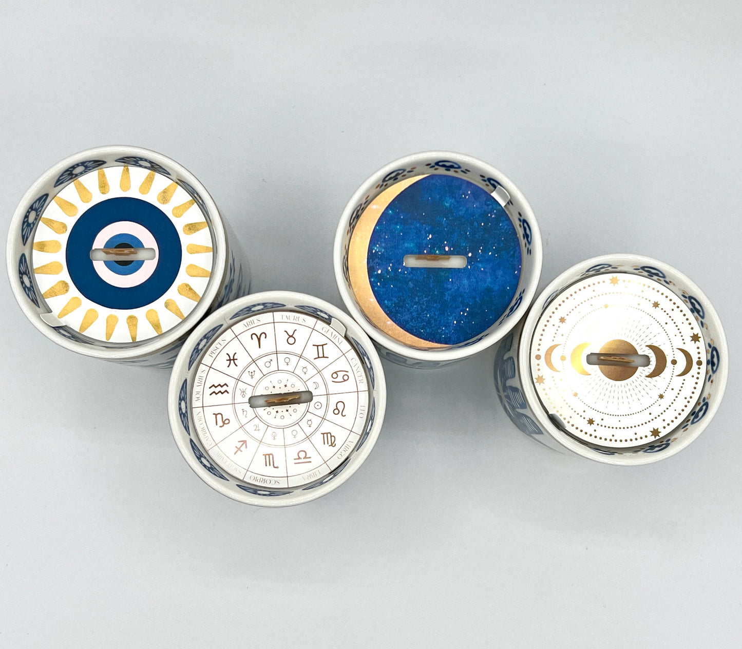 Four circular decorative items with astrological designs on a light gray background
