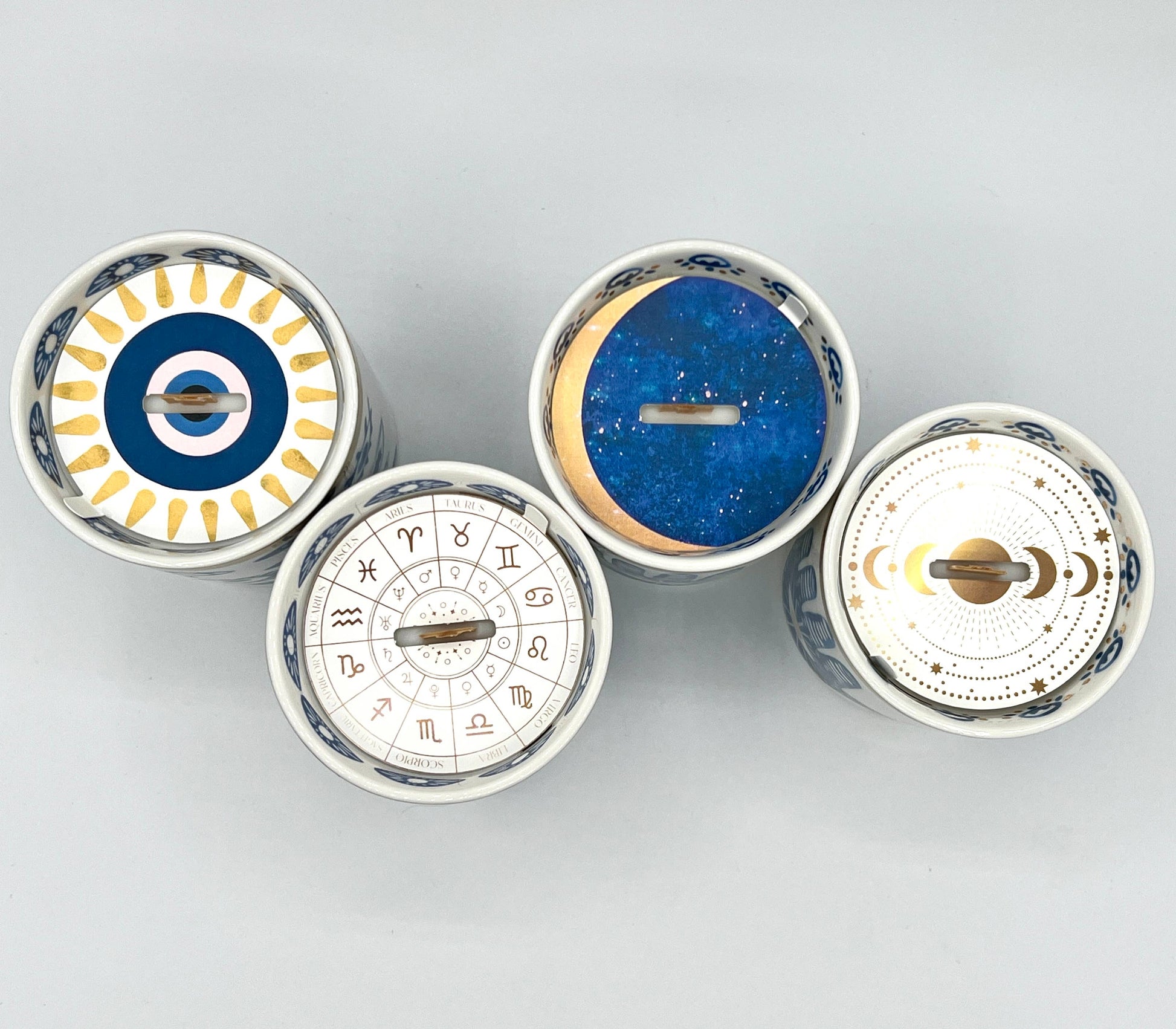 Four circular decorative items with astrological designs on a light gray background